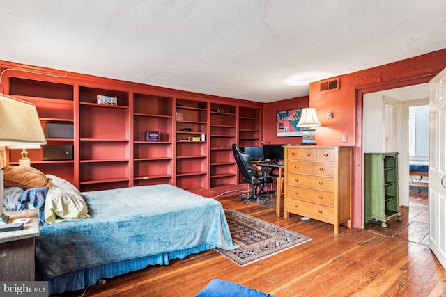 bedroom with hardwood / wood-style floors and a textured ceiling