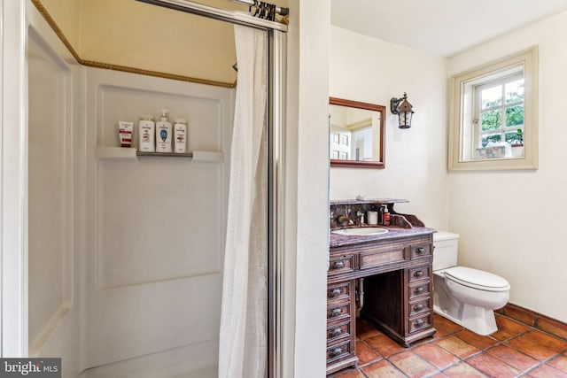 bathroom featuring toilet, vanity, and walk in shower