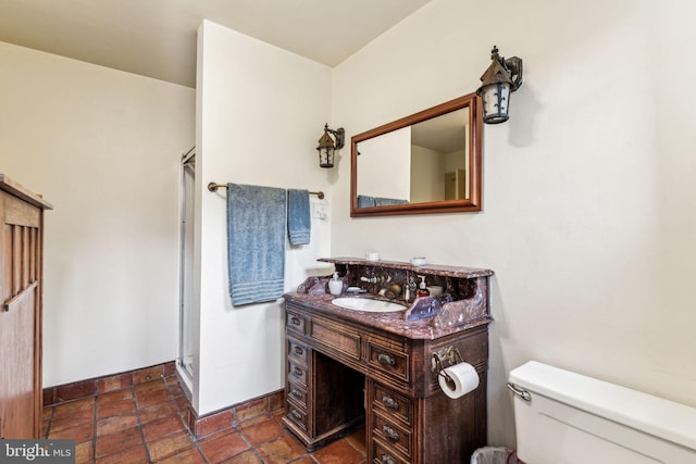 bathroom with walk in shower, vanity, and toilet