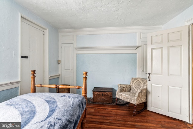 bedroom with dark hardwood / wood-style floors and a textured ceiling