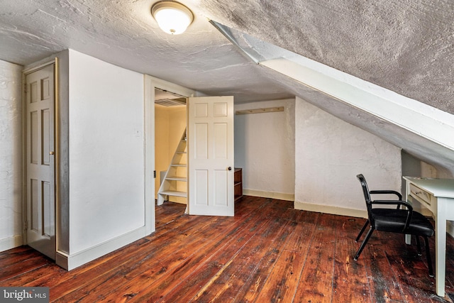 unfurnished office with a textured ceiling, dark hardwood / wood-style floors, and vaulted ceiling