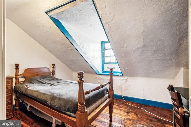 bedroom featuring a textured ceiling, lofted ceiling, and dark wood-type flooring