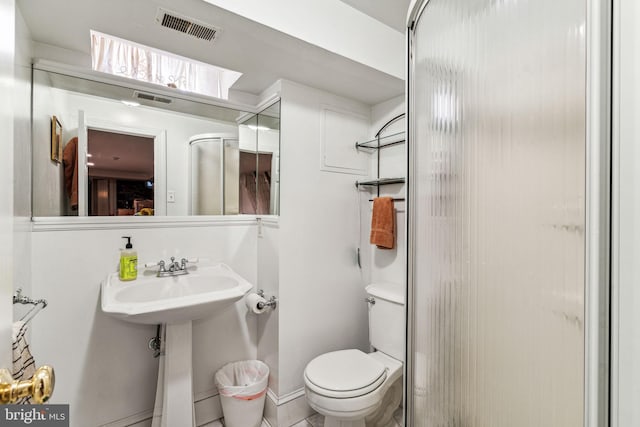 bathroom featuring tile patterned flooring, toilet, and walk in shower