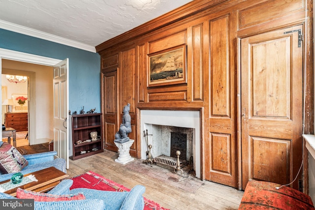 living room featuring ornamental molding, a textured ceiling, and light hardwood / wood-style flooring