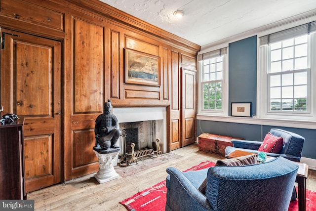 sitting room with light wood-type flooring and ornamental molding