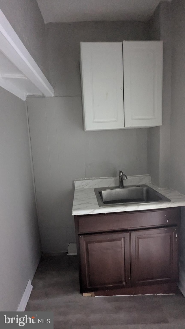 clothes washing area featuring dark hardwood / wood-style floors and sink