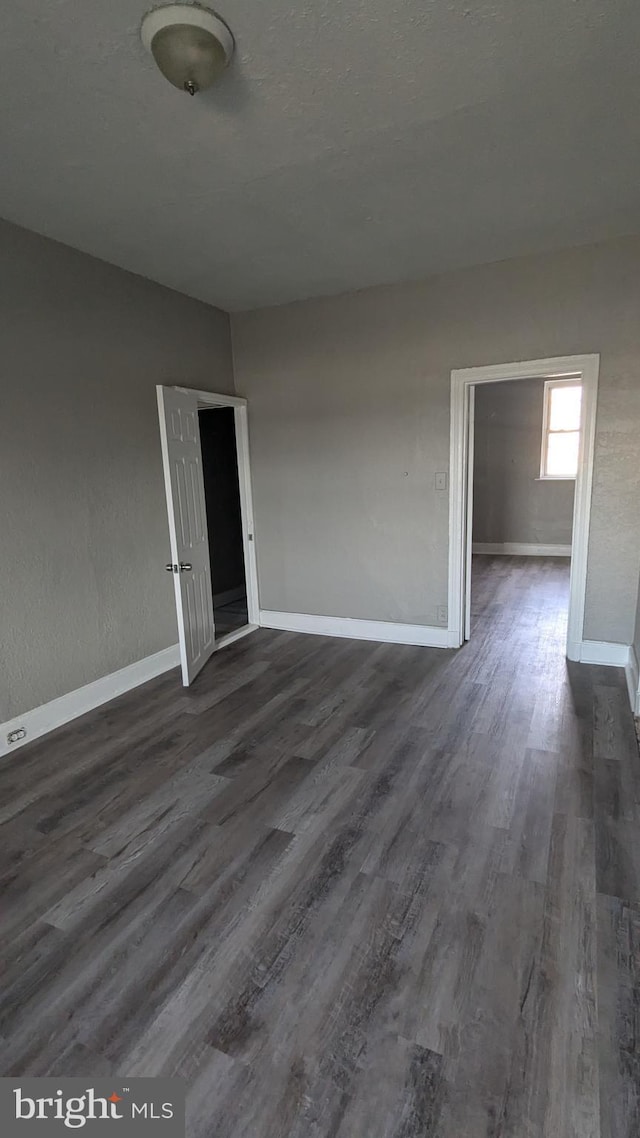 unfurnished room with dark hardwood / wood-style floors