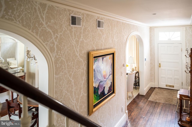 entryway with crown molding and dark wood-type flooring