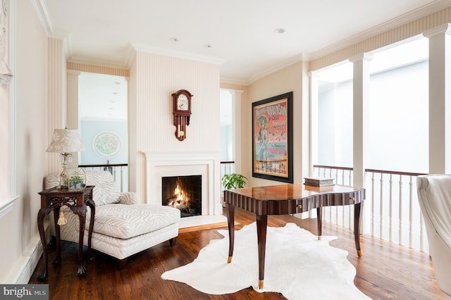 living area featuring a healthy amount of sunlight, hardwood / wood-style flooring, and ornamental molding