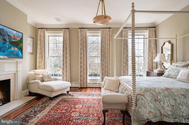 bedroom featuring hardwood / wood-style floors, ornamental molding, and baseboard heating