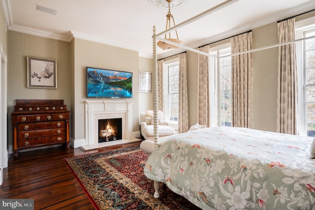 bedroom with dark hardwood / wood-style floors, ornamental molding, and an inviting chandelier