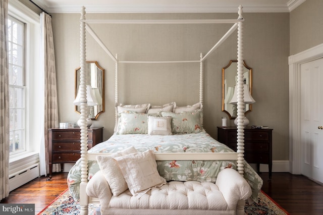 bedroom featuring wood-type flooring, crown molding, and baseboard heating