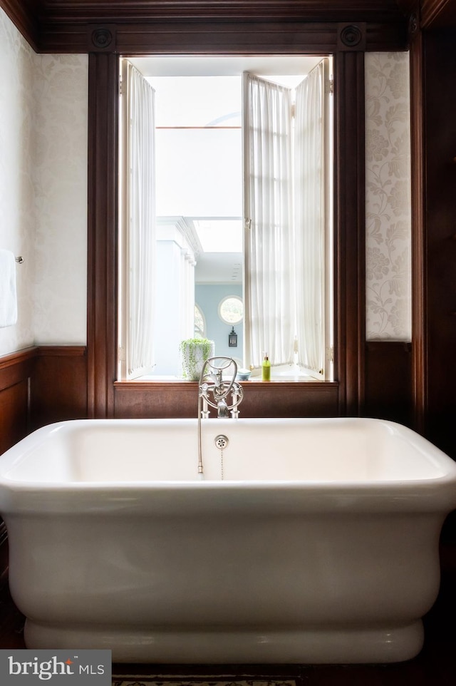 bathroom featuring wood walls and a bathtub