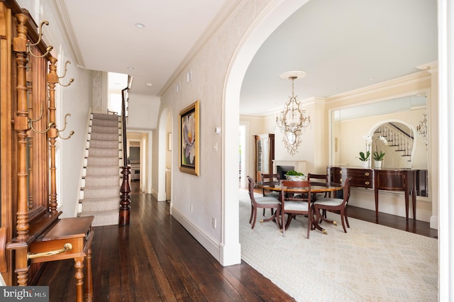 interior space with crown molding, dark wood-type flooring, and an inviting chandelier