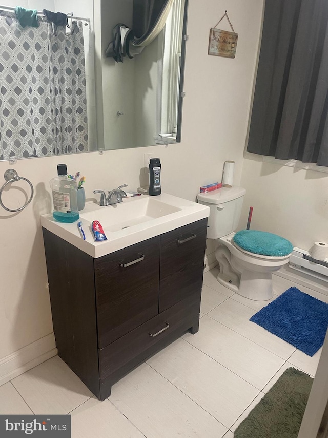 bathroom featuring toilet, vanity, tile patterned floors, and a baseboard heating unit