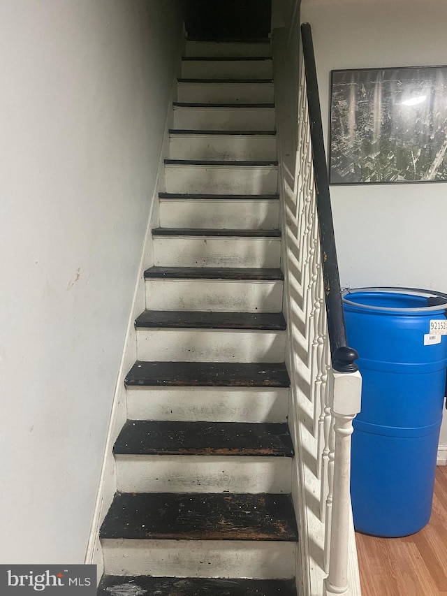 stairs featuring hardwood / wood-style floors