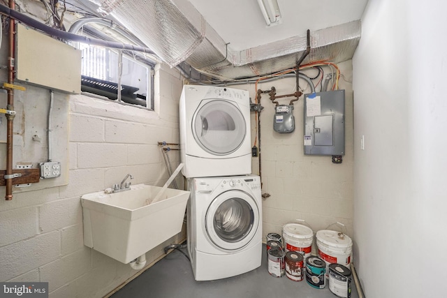 laundry room with stacked washer / drying machine, sink, and electric panel