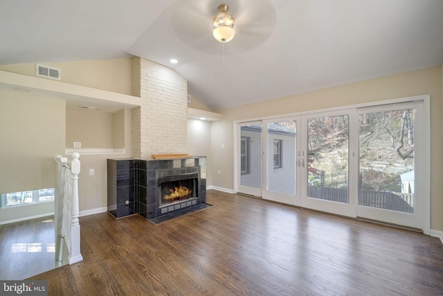 living room featuring ceiling fan, a fireplace, dark hardwood / wood-style floors, and vaulted ceiling