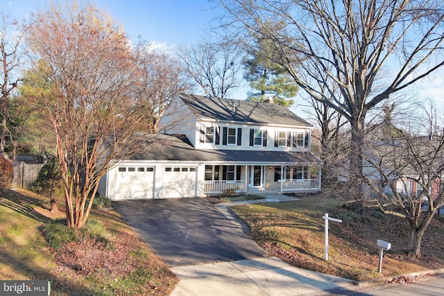 view of front facade with a porch, a garage, and a front lawn