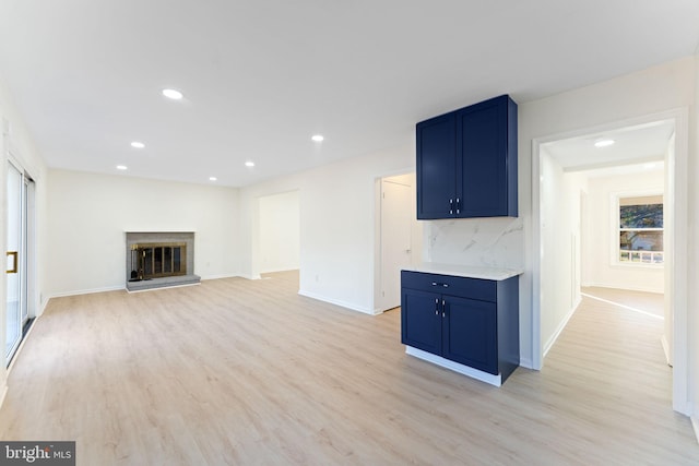 unfurnished living room featuring a fireplace and light hardwood / wood-style flooring