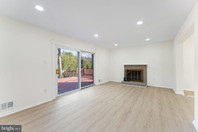 unfurnished living room featuring light wood-type flooring and a fireplace