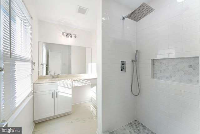 bathroom with vanity and tiled shower