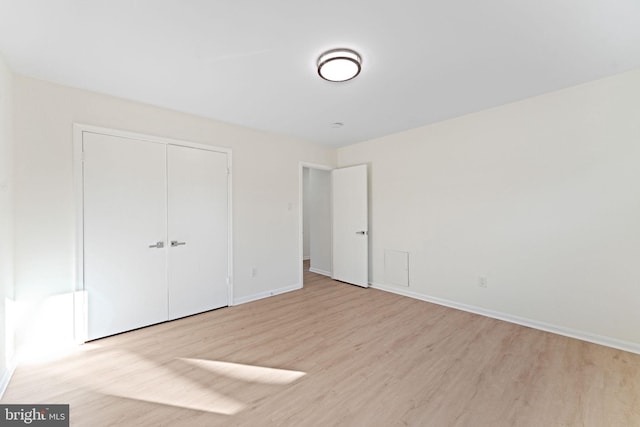 unfurnished bedroom with a closet and light hardwood / wood-style flooring