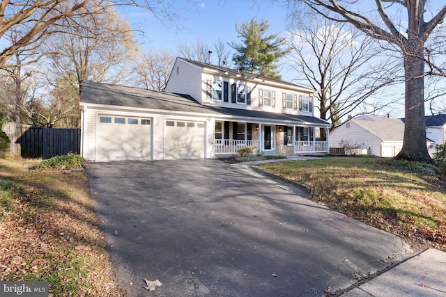 view of front property with covered porch, a garage, and a front lawn