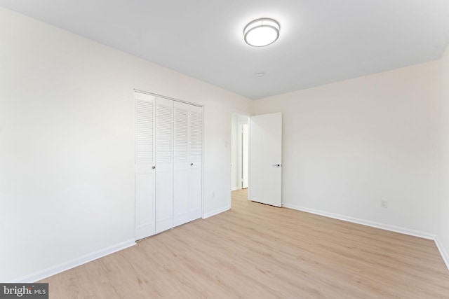 unfurnished bedroom featuring light hardwood / wood-style floors and a closet