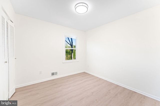 unfurnished bedroom with light wood-type flooring and a closet