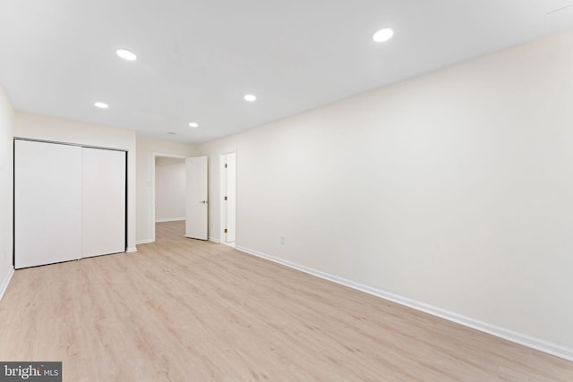 unfurnished bedroom with a closet and light wood-type flooring