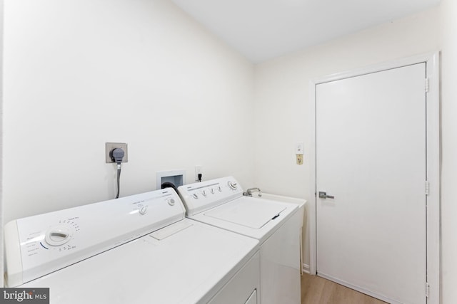 laundry room featuring washer and dryer and light hardwood / wood-style floors