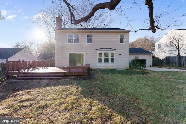 rear view of property featuring a yard and a deck