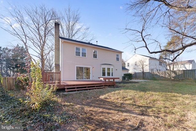 rear view of property with a lawn and a wooden deck