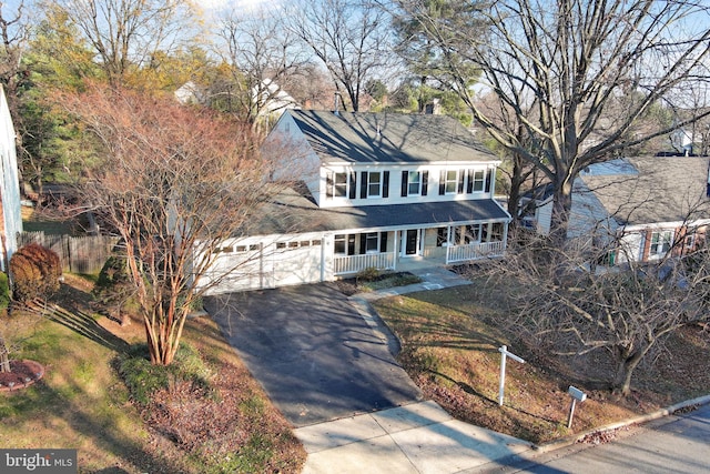 view of front facade with a porch, a garage, and a front lawn