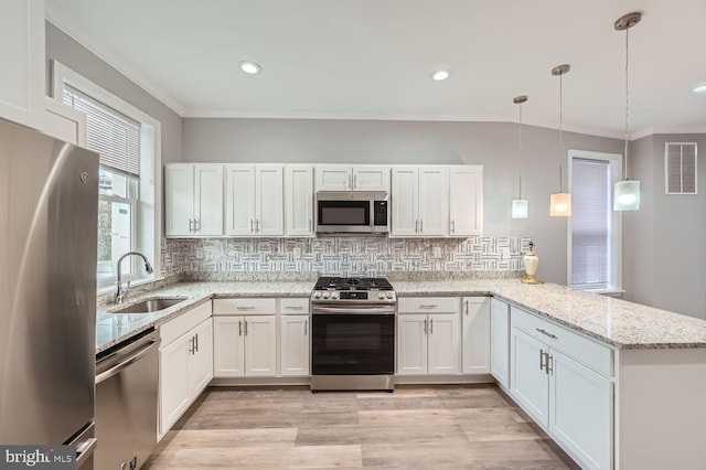 kitchen with white cabinetry, kitchen peninsula, hanging light fixtures, and appliances with stainless steel finishes