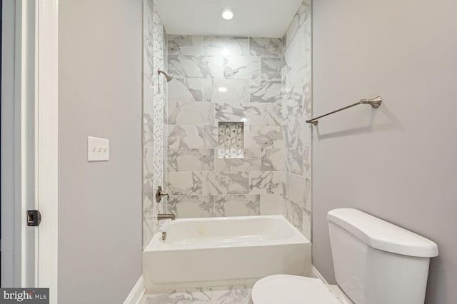 bathroom featuring toilet and tiled shower / bath