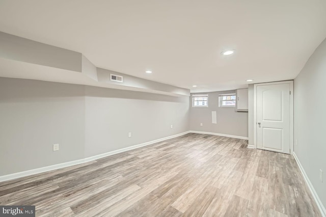 basement with light hardwood / wood-style flooring