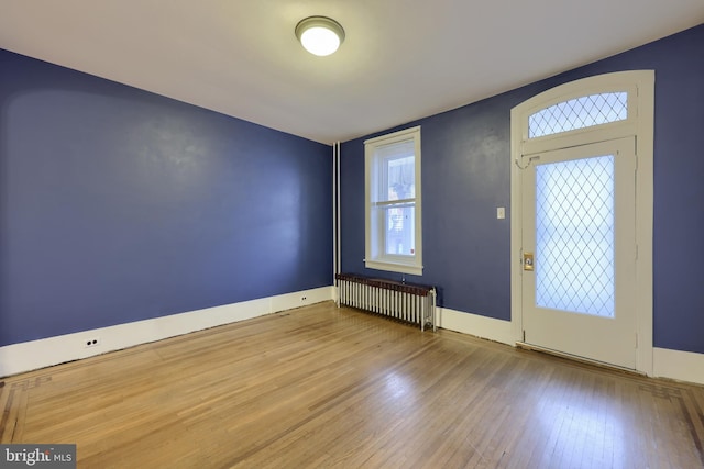 entrance foyer with radiator heating unit and hardwood / wood-style floors