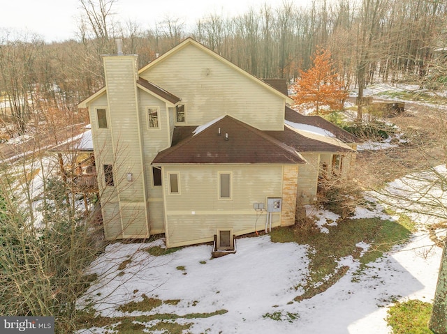 view of snow covered rear of property