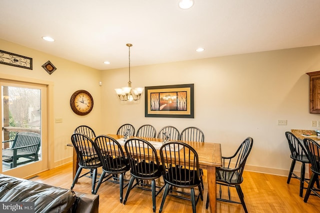 dining room with light wood-type flooring and a chandelier