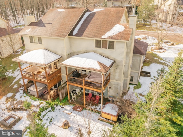 snow covered house featuring a deck