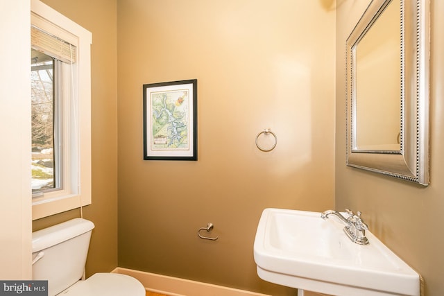 bathroom with plenty of natural light, toilet, and sink