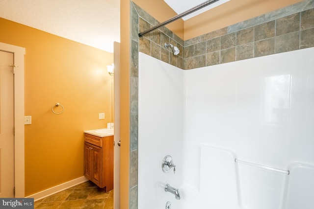 bathroom featuring tile patterned flooring, vanity, and tiled shower / bath combo