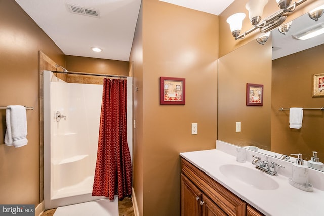 bathroom with a shower with shower curtain, vanity, and a notable chandelier