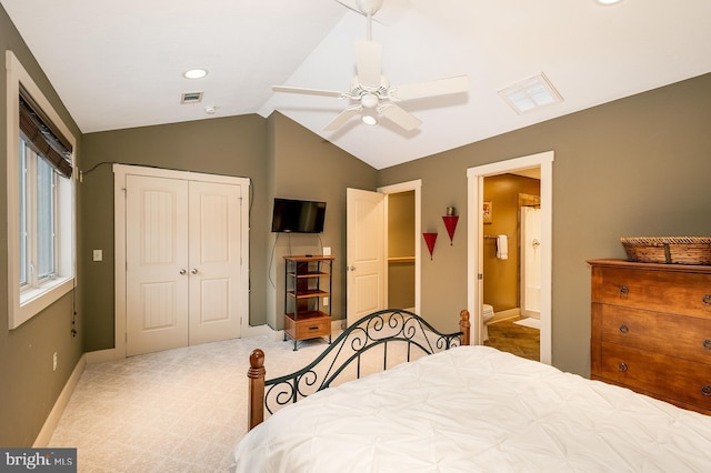 bedroom with light colored carpet, vaulted ceiling, ceiling fan, connected bathroom, and a closet