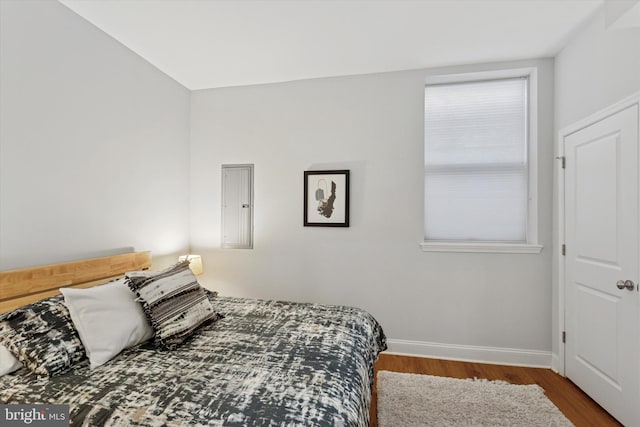 bedroom with baseboards and wood finished floors