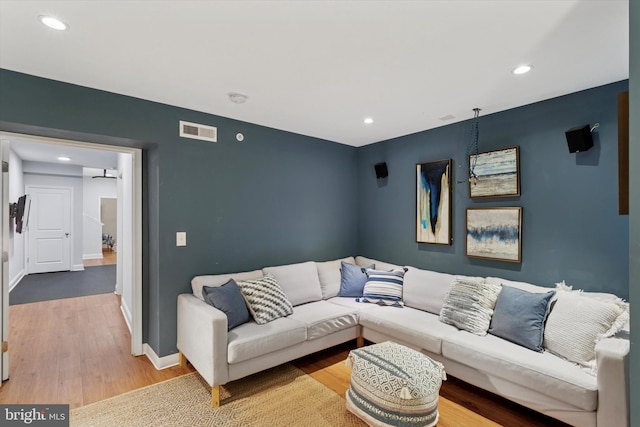 living area with recessed lighting, visible vents, and wood finished floors