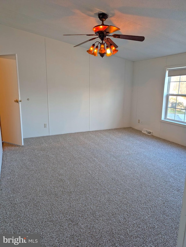 carpeted empty room featuring ceiling fan