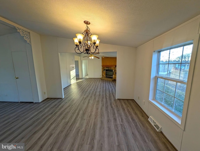 unfurnished dining area with lofted ceiling, a chandelier, a healthy amount of sunlight, and dark hardwood / wood-style floors